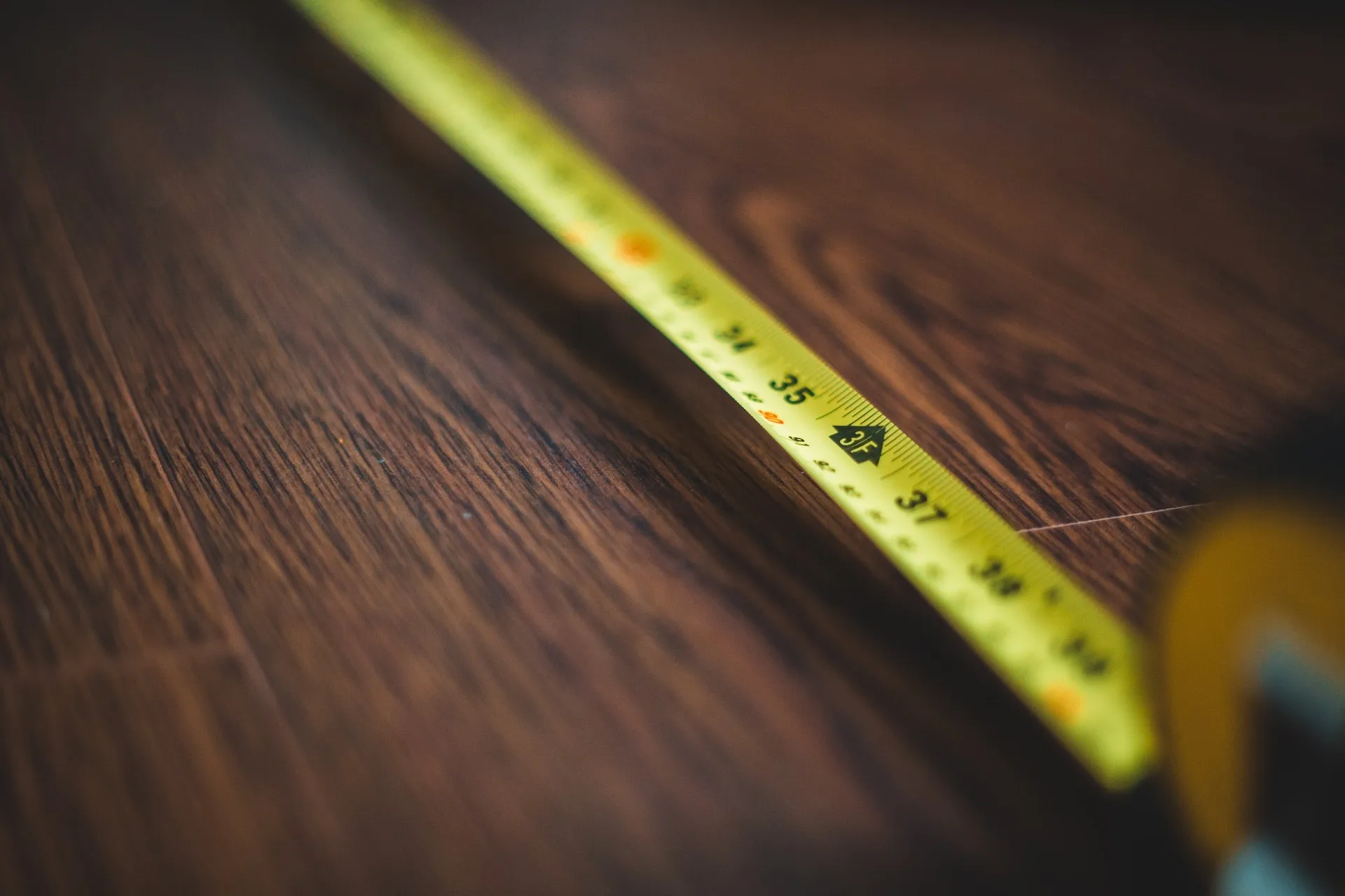 a yellow tape measure on a wood surface